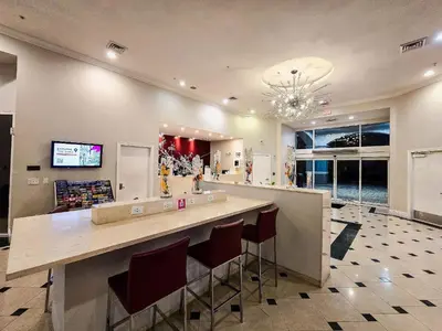 a lobby with a bar with stools and a tv at Flats moderno 4min da Universal - The Point Orlando in Orlando