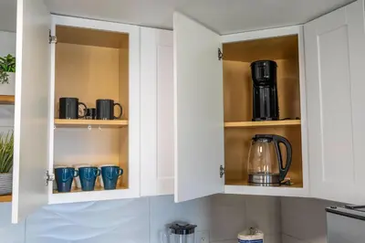 a kitchen with white cabinets with pots and pans at Modern 2BR Near Universal in Orlando