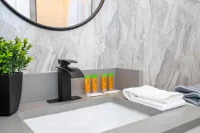 a bathroom sink with a faucet and a mirror at Modern 2BR Near Universal in Orlando