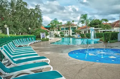 a group of lounge chairs next to a swimming pool at Wyndham Star Island Resort-1BR- Apartment with Resort Access in Kissimmee