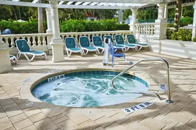 a jacuzzi tub on a patio with chairs at Wyndham Star Island Resort-2BR- Apartment with Resort Access in Kissimmee