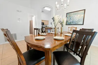 a dining room with a wooden table and chairs at Elegant Emerald Island – Near Disney in Kissimmee