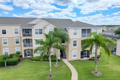 a large apartment building with palm trees in front of it at Refúgio 3Q no Windsor Palms Resort in Kissimmee