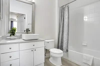 a white bathroom with a toilet and a sink at Refúgio 3Q no Windsor Palms Resort in Kissimmee