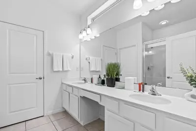 a white bathroom with two sinks and a large mirror at Home 08 Bedrooms At Bella Vida in Kissimmee