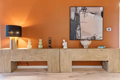 a wooden console table in a room with an orange wall at Home 08 Bedrooms At Bella Vida in Kissimmee
