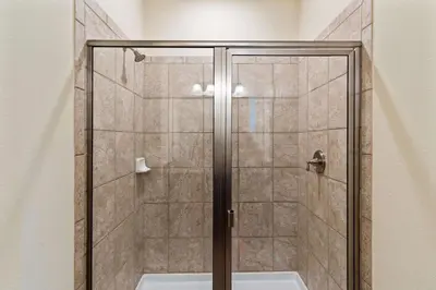a shower with a glass door in a bathroom at Vila 8Q Disney c/ Piscina, Spa e Bar Temático in Orlando