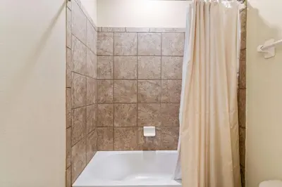 a bathroom with a tub and a shower curtain at Vila 8Q Disney c/ Piscina, Spa e Bar Temático in Orlando