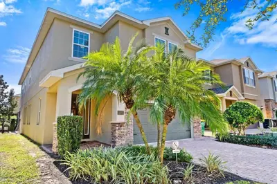 a house with palm trees in front of it at Vila 8Q Disney c/ Piscina, Spa e Bar Temático in Orlando
