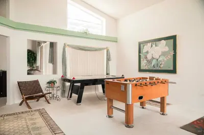 a living room with a table and a pool table at 15 Mins Disneyworld Private Pool & Game Room in Kissimmee