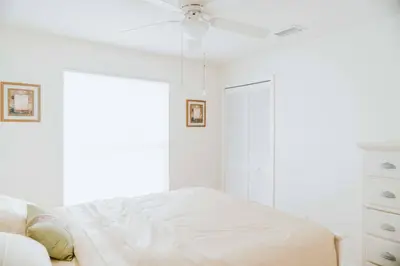 a white bedroom with a bed and a ceiling fan at 10 min to Disney | Karaoke | Game in Kissimmee