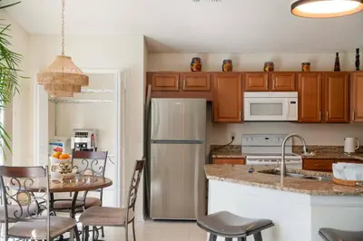 a kitchen with a refrigerator and a table with chairs at 10 min to Disney | Karaoke | Game in Kissimmee