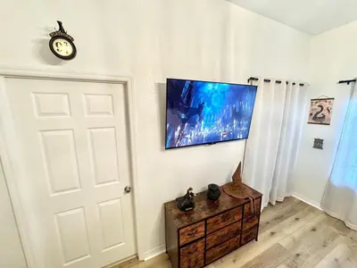 a room with a white door and a clock on a wall at 2BR Condo Close to Disney - Gated, Pool & Hot Tub in Kissimmee