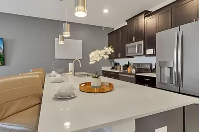 a kitchen with a large white island in a kitchen at Casa Familiar 10min da Disney + Piscina Privativa in Kissimmee