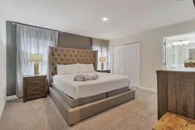 a bedroom with a large white bed and a sink at Casa Familiar 10min da Disney + Piscina Privativa in Kissimmee
