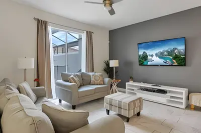 a living room with a couch and a tv at Casa Familiar 10min da Disney + Piscina Privativa in Kissimmee