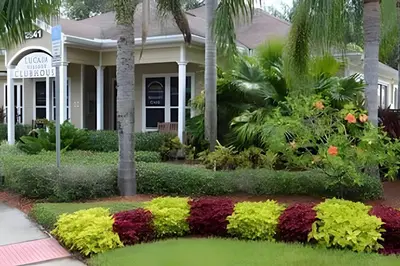 a house with a flower garden in front of it at Casa 3Q Moderna c/ Piscina e Clube Resort in Kissimmee