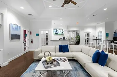 a living room with a white couch and blue pillows at Casa 3Q Moderna c/ Piscina e Clube Resort in Kissimmee