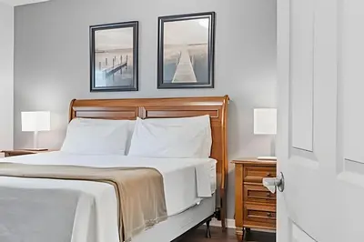 a bedroom with a bed with two pictures on the wall at Casa 3Q Moderna c/ Piscina e Clube Resort in Kissimmee