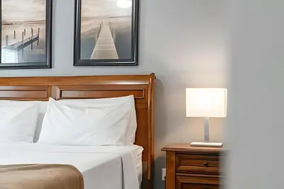 a bedroom with a bed and a table with a lamp at Casa 3Q Moderna c/ Piscina e Clube Resort in Kissimmee