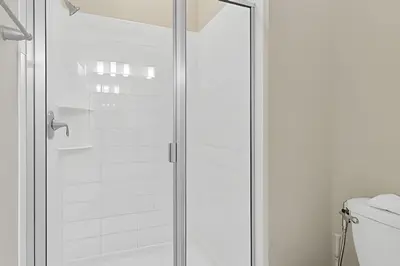 a glass shower door in a bathroom with a toilet at Casa 5Q Familiar — 10min da Disney + Piscina in Kissimmee