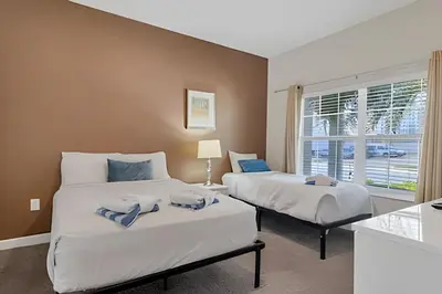 a bedroom with two beds and a window at Casa 4Q Moderna c/ Lazy River e Toboáguas in Kissimmee