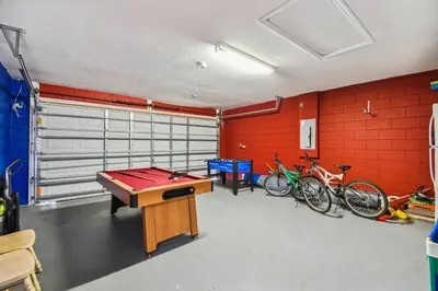 a garage with a ping pong table and some bikes at Casa 4Q no Lake Berkley c/ Piscina Privativa in Kissimmee