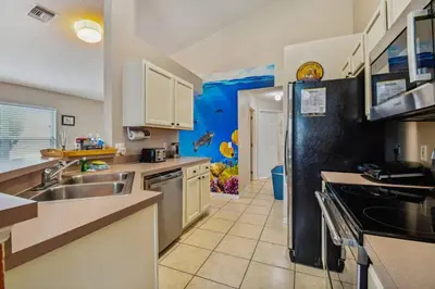 a kitchen with a sink and a refrigerator at Casa 4Q no Lake Berkley c/ Piscina Privativa in Kissimmee