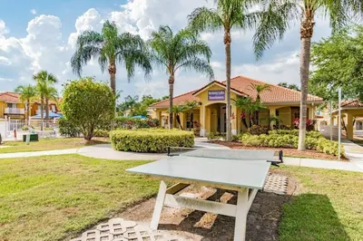 a ping pong table in front of a house with palm trees at Casa 4Q no Lake Berkley c/ Piscina Privativa in Kissimmee