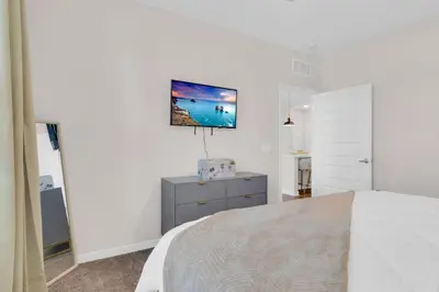 a bedroom with a bed and a tv on the wall at Modern 2 Bedrm Apartment with fast Wi-fi - Apartment in Orlando