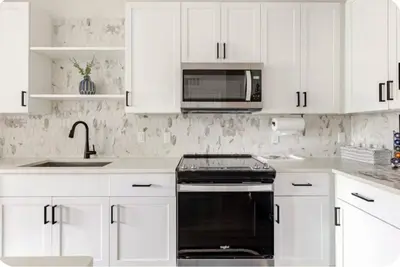 a kitchen with white cabinets and a stove and microwave at LuXury Stay | Pool + Gym + Fast Wi-fi in Orlando