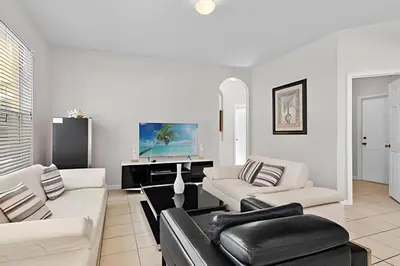 a living room with white furniture and a flat screen tv at Casa 5Q Piscina Resort Windsor Hills Disney in Orlando