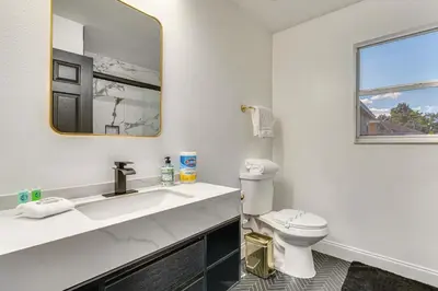 a white bathroom with a sink and a toilet at Modern Resort Getaway 9 Mi to Disney Parks! in Kissimmee
