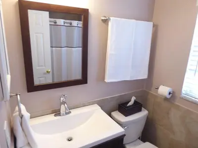 a bathroom with a sink and a toilet and a mirror at Perfecto Mundo 3, Orlando Area 5BR-2BA-Outdoor Pool-Jacuzzi-Billiard in Orlando