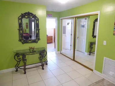 a room with green walls and a mirror and a table at Perfecto Mundo 3, Orlando Area 5BR-2BA-Outdoor Pool-Jacuzzi-Billiard in Orlando