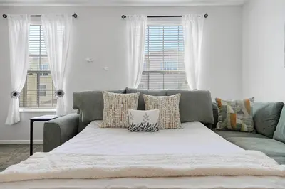 a couch with pillows in a living room with windows at Epic Universe Vacation Townhome, Vista Cay - 4035 in Orlando