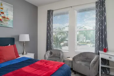 a bedroom with a bed and two chairs and a window at Heated Pool Game Room Waterpark 9MI to Disney in Kissimmee