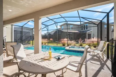 a patio with a table and chairs and a pool at Heated Pool Game Room Waterpark 9MI to Disney in Kissimmee