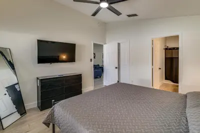 a bedroom with a bed and a flat screen tv at 10 Mi to Animal Kingdom Clermont Home with Pool! in Orlando