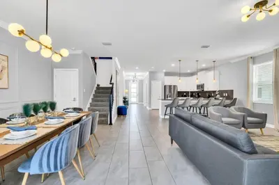 a dining room and living room with a table and chairs at Storey Lake Casa 9Q c Piscina, Cinema e Game Room in Kissimmee