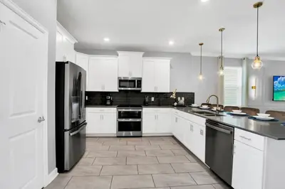 a kitchen with white cabinets and black appliances at Storey Lake Casa 9Q c Piscina, Cinema e Game Room in Kissimmee