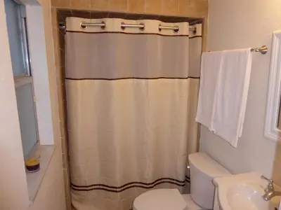 a bathroom with a shower curtain and a toilet at Perfecto Mundo 4, Orlando Area 4BR-2BA Jacuzzi-Billiard-Ping Pong-City Pool in Orlando