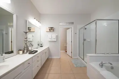 a white bathroom with two sinks and a shower at The Epic Barcelona Penthouse Vista Cay Orlando Florida in Orlando