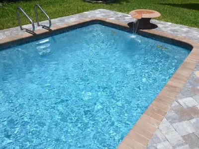 a swimming pool with a fountain in a yard at Perfecto Mundo 1, Orlando Area 5BR-2BA Outdoor Pool, Ping Pong, Billiard in Orlando