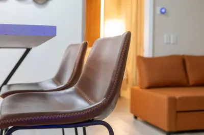 two leather chairs sitting next to a table and a couch at Modern Unit w Themed Room, Full Kitchen and Prime Location in Orlando