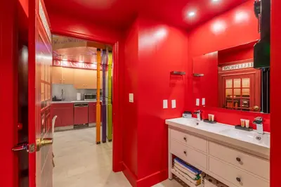 a red bathroom with a sink and a red wall at Wizard Themed Suite near Universal and Epic in Orlando