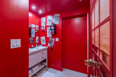 a red bathroom with a sink and a red door at Wizard Themed Suite near Universal and Epic in Orlando