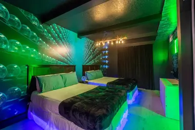 a bedroom with two beds with green and purple lights at Wizard Themed Suite near Universal and Epic in Orlando