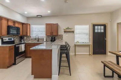 a kitchen with wooden cabinets and a counter top at Jacuzzi and Games Close to Dwtn Disney and Parks in Orlando