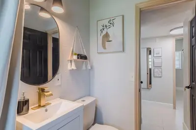a bathroom with a sink and a toilet and a mirror at Jacuzzi and Games Close to Dwtn Disney and Parks in Orlando